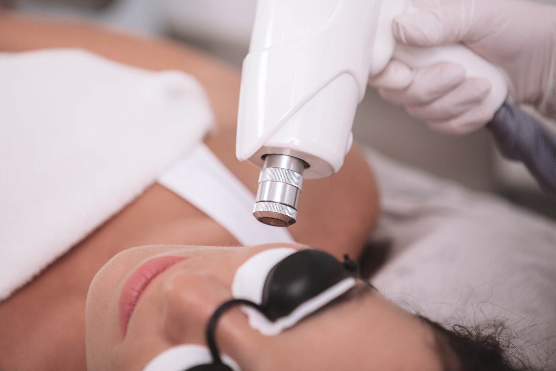 Close view of a laser hair removal session on a client's skin at a medical aesthetics clinic
