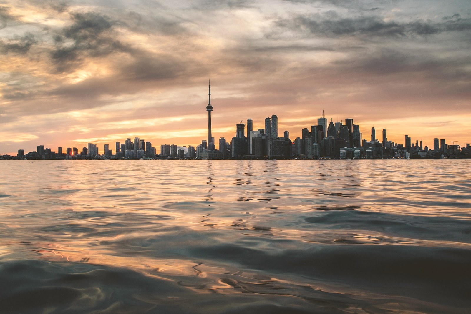 The Toronto skyline and CN Tower at golden hour seen from the water