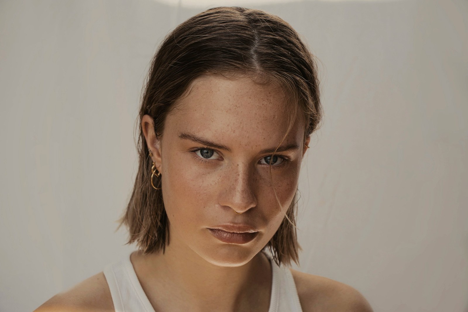 A woman with bare skin and visible freckles in natural light