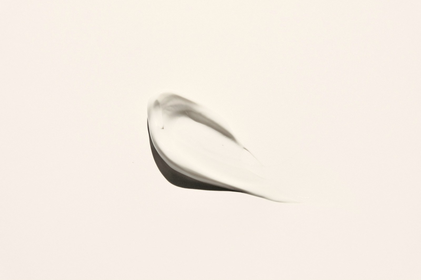 A smear of white cosmetic cream on a pale surface