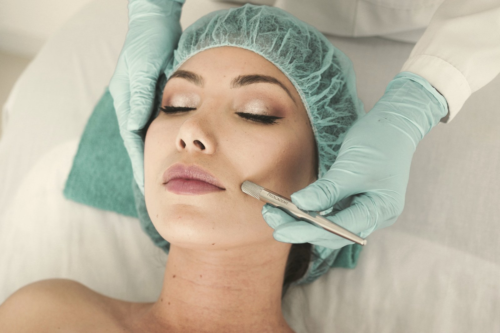 A gloved clinician performing a facial treatment on a patient